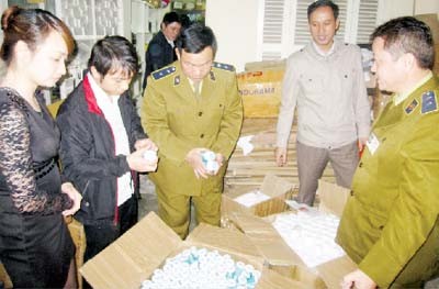 Investigation police check cartons of fake drugs in Hanoi